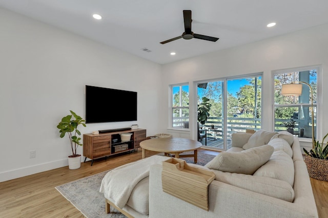 living room with ceiling fan, plenty of natural light, and hardwood / wood-style flooring