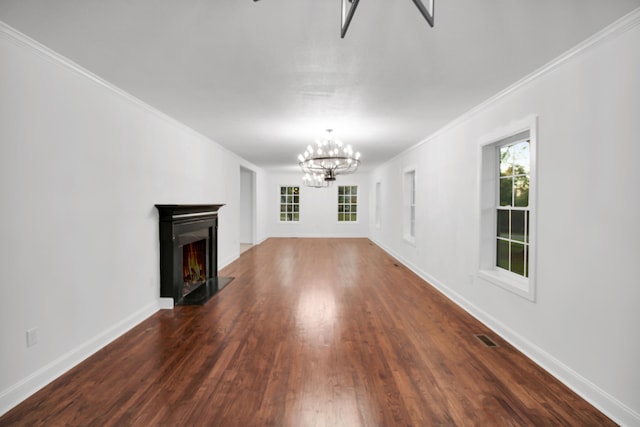 unfurnished living room with a lit fireplace, baseboards, a chandelier, and wood finished floors