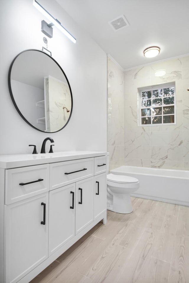 full bathroom with bathtub / shower combination, toilet, wood finished floors, visible vents, and vanity