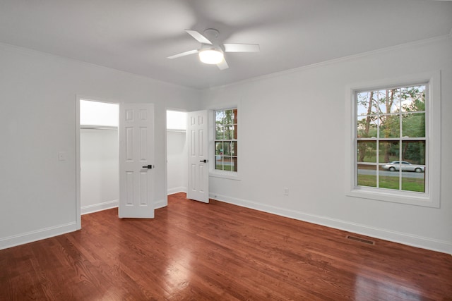 unfurnished bedroom featuring visible vents, crown molding, baseboards, and wood finished floors