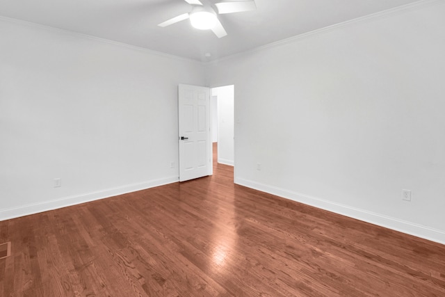 spare room featuring baseboards, ceiling fan, wood finished floors, and crown molding