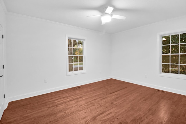 spare room featuring a ceiling fan, crown molding, baseboards, and wood finished floors