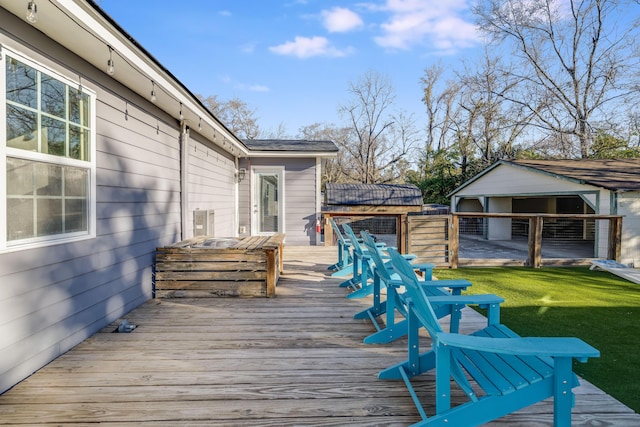 wooden deck featuring an outbuilding and a yard