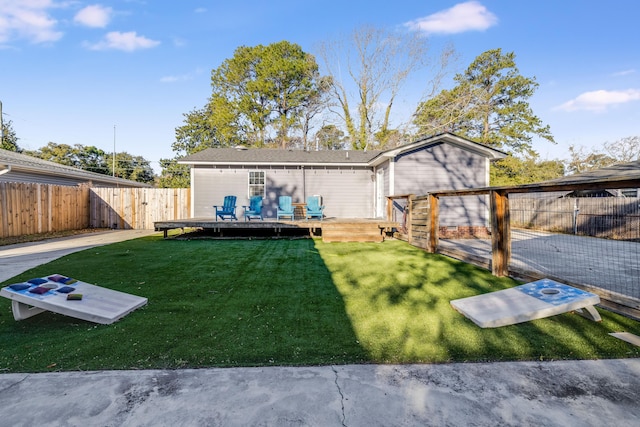 back of house featuring a deck, a lawn, and a fenced backyard