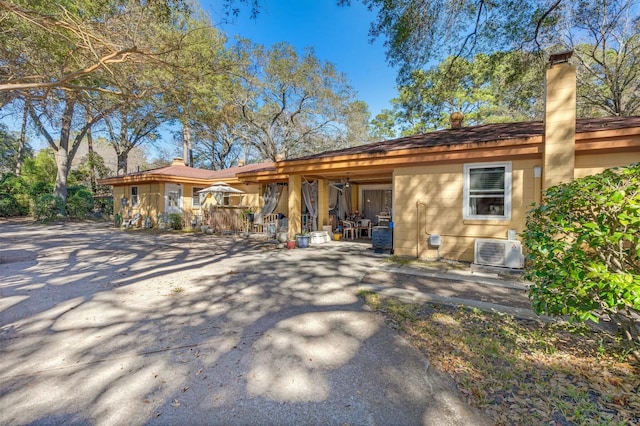 view of front facade featuring ac unit, a patio area, and a chimney