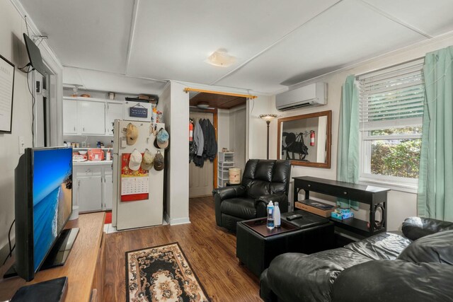 living area with a wall mounted AC and wood finished floors