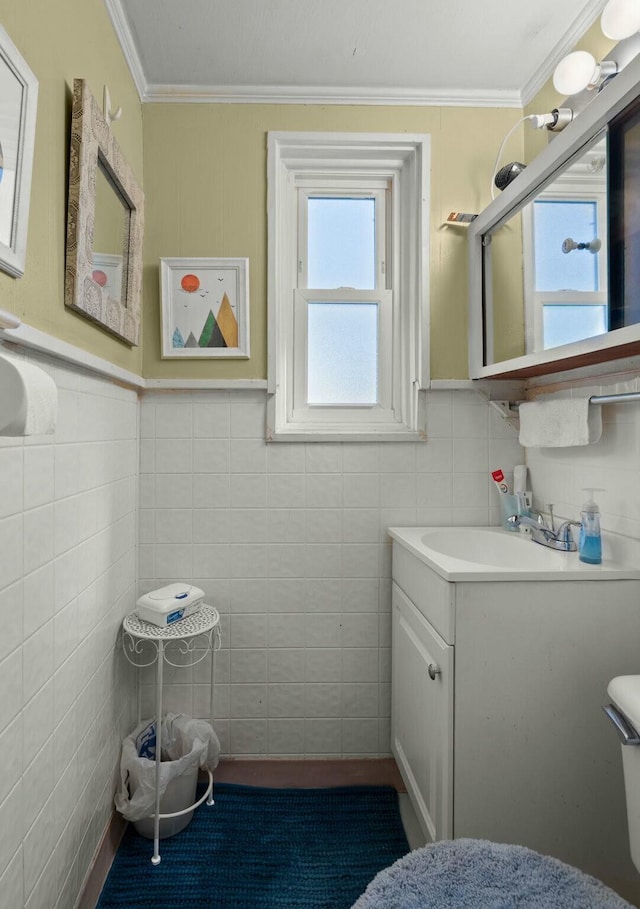 half bath featuring toilet, ornamental molding, vanity, and tile walls