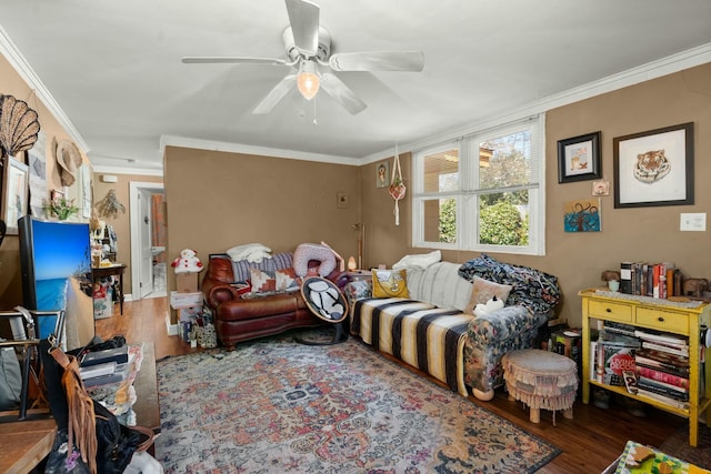 living room featuring ornamental molding, a ceiling fan, and wood finished floors