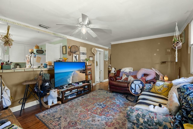 living room with baseboards, visible vents, ceiling fan, wood finished floors, and crown molding