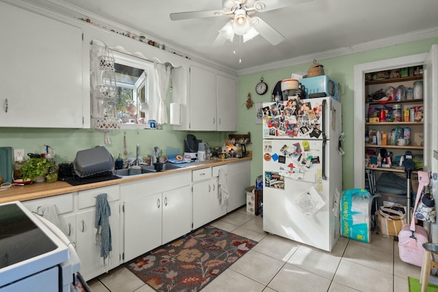 kitchen featuring crown molding, light tile patterned floors, white cabinetry, a sink, and white appliances