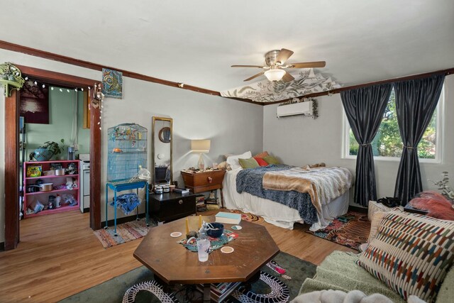 bedroom featuring a ceiling fan, a wall unit AC, and wood finished floors