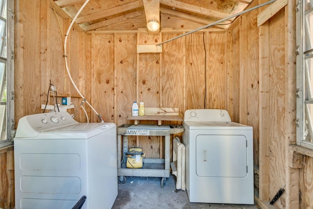 laundry area featuring laundry area, separate washer and dryer, and wooden walls