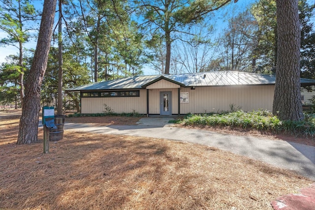 view of front of house featuring driveway and metal roof