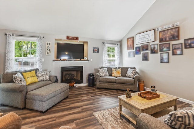 living room featuring dark wood-type flooring, baseboards, vaulted ceiling, and a fireplace