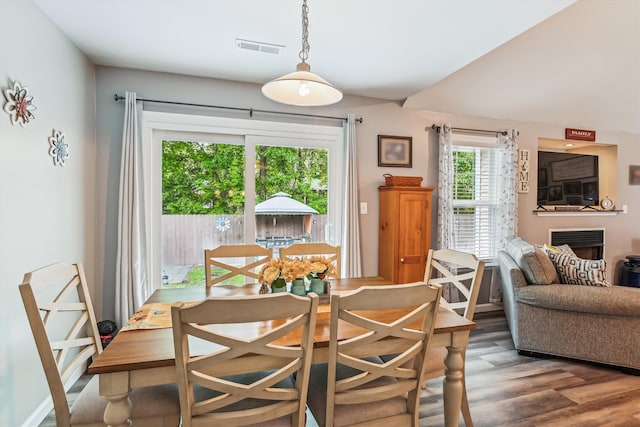 dining space with visible vents, wood finished floors, and a fireplace