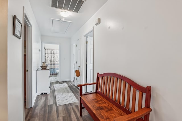 corridor with visible vents, attic access, and wood finished floors