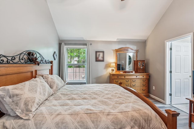 bedroom featuring baseboards, vaulted ceiling, and wood finished floors