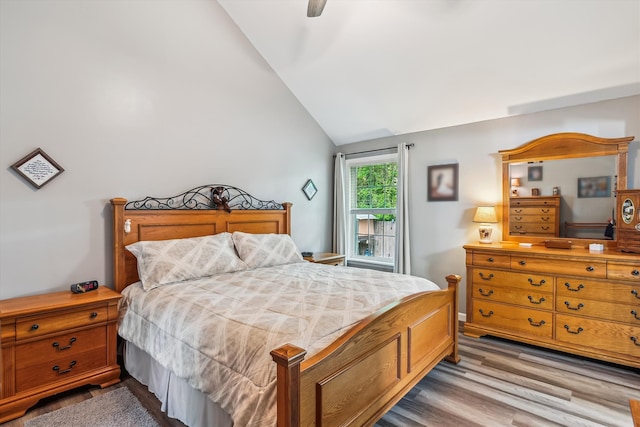 bedroom with a ceiling fan, wood finished floors, and lofted ceiling