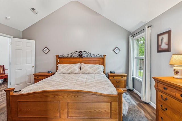 bedroom featuring baseboards, visible vents, dark wood-style floors, and lofted ceiling
