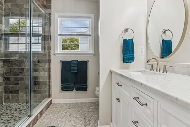 bathroom featuring toilet, a shower stall, a wealth of natural light, and vanity