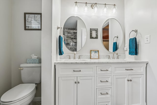 full bathroom with double vanity, a sink, a tile shower, and toilet
