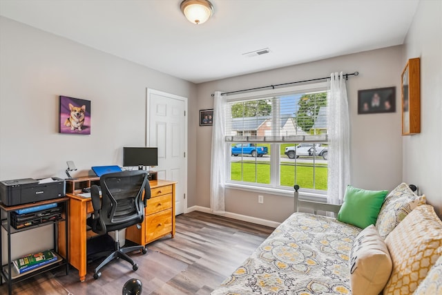office space with visible vents, baseboards, and wood finished floors