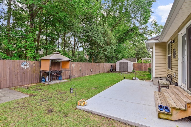 view of yard featuring a fenced backyard, an outbuilding, a patio area, and a shed