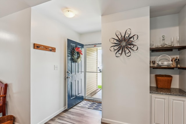 foyer entrance featuring light wood-style floors and baseboards