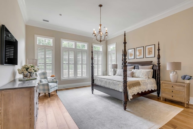 bedroom featuring light wood-type flooring, ornamental molding, and a notable chandelier