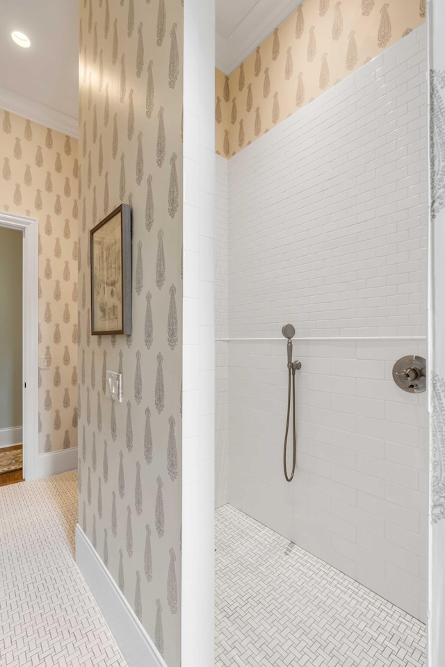 bathroom featuring a tile shower and ornamental molding