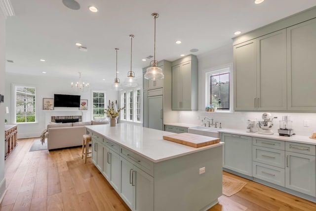 kitchen featuring a center island, paneled built in fridge, light hardwood / wood-style floors, sink, and white dishwasher