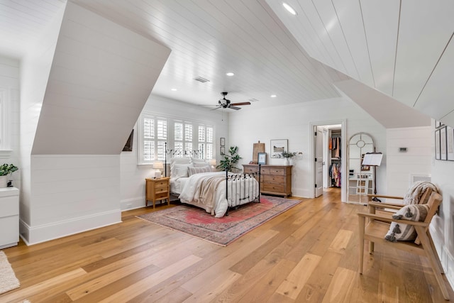 bedroom with a spacious closet, a closet, ceiling fan, wooden ceiling, and light hardwood / wood-style flooring