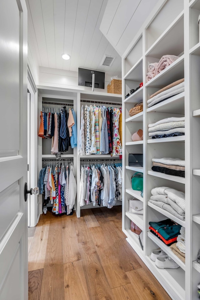 walk in closet with light hardwood / wood-style flooring