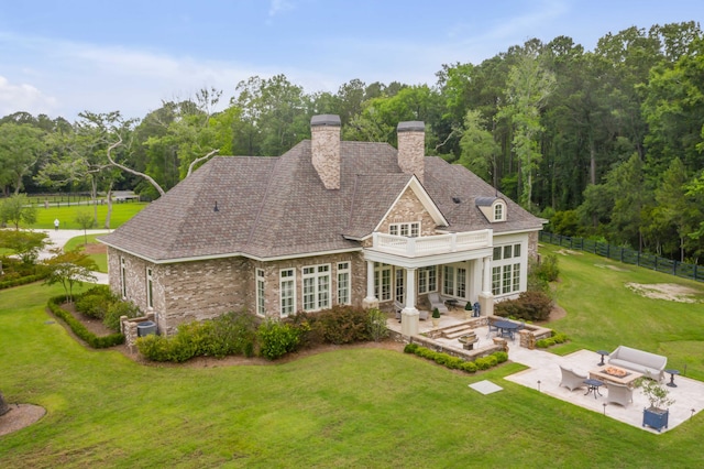 rear view of property with a patio area, outdoor lounge area, and a yard