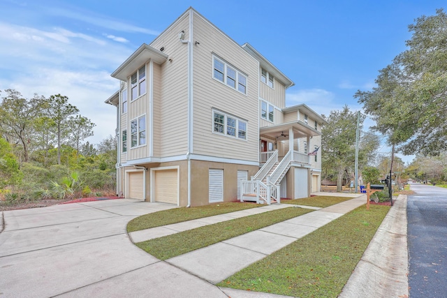 view of front of property with a garage, concrete driveway, stucco siding, and stairs