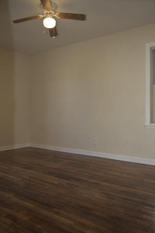 spare room featuring dark wood-type flooring and ceiling fan