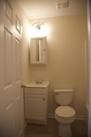 bathroom with vanity, toilet, tile patterned flooring, and a bath