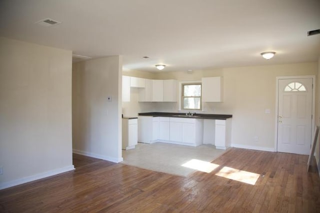 kitchen featuring sink, white cabinets, and light hardwood / wood-style flooring