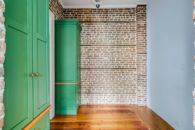 spare room with hardwood / wood-style floors and brick wall