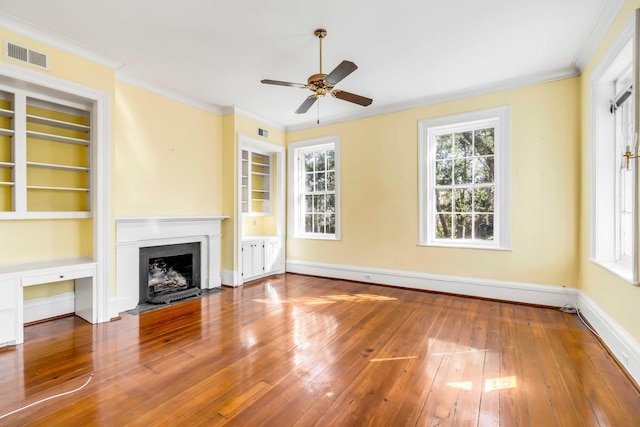52 Hasell St, Charleston, SC 29401 - unfurnished living room featuring wood-type flooring, a ceiling fan, built in shelves, crown molding, and a fireplace with flush hearth