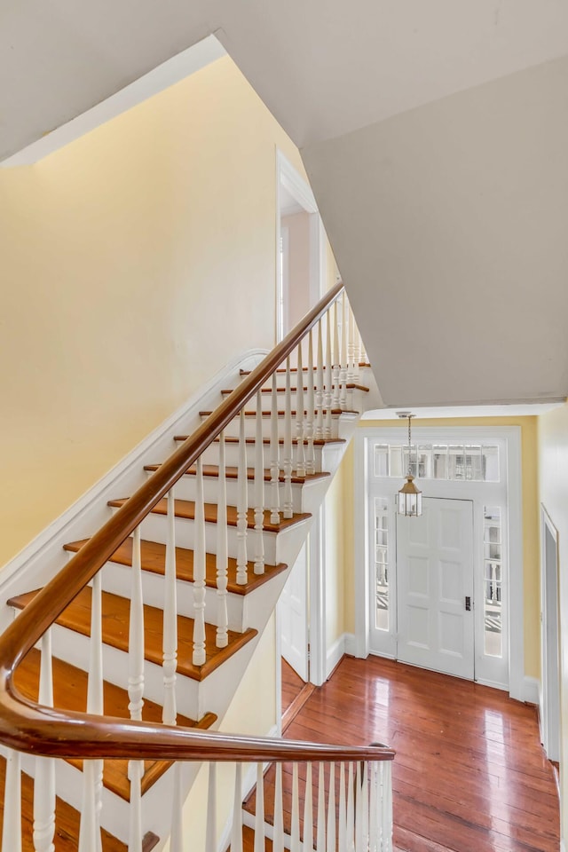 foyer featuring wood-type flooring and lofted ceiling