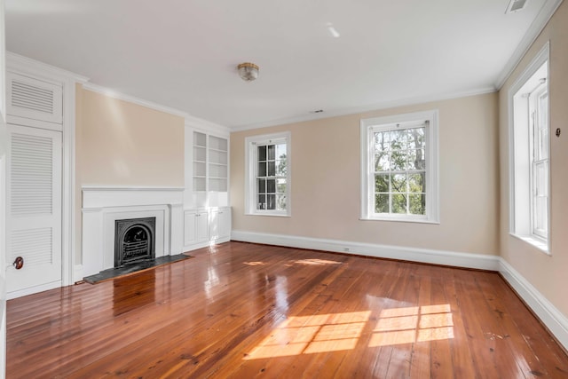 52 Hasell St, Charleston, SC 29401 - unfurnished living room featuring hardwood / wood-style flooring, baseboards, built in features, a fireplace with flush hearth, and crown molding
