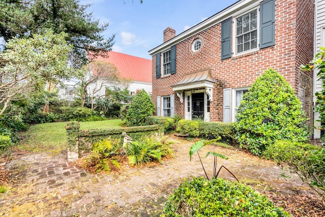 52 Hasell St, Charleston, SC 29401 - view of front of property with brick siding, a chimney, a standing seam roof, and metal roof