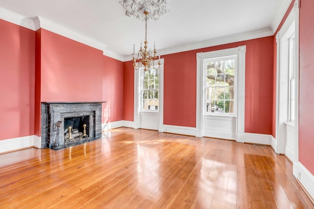 unfurnished living room featuring a chandelier, wood-type flooring, and ornamental molding