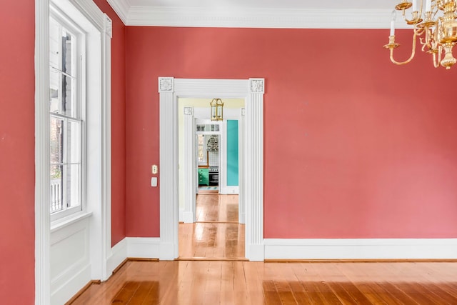 hallway featuring hardwood / wood-style flooring, an inviting chandelier, and ornamental molding