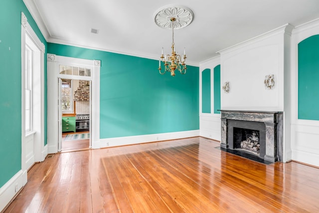 52 Hasell St, Charleston, SC 29401 - unfurnished living room with a chandelier, a premium fireplace, ornamental molding, and hardwood / wood-style floors