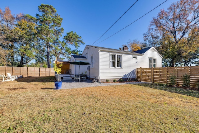 back of property featuring a patio and a lawn