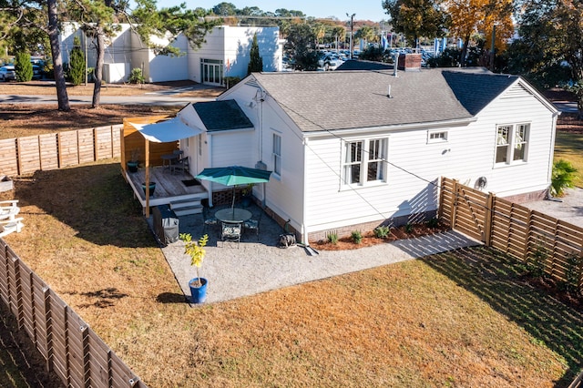 rear view of house with a wooden deck and a yard