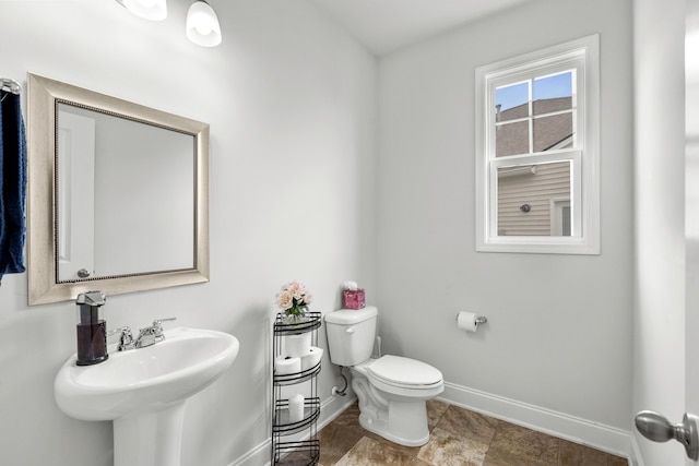 bathroom featuring baseboards, a sink, and toilet