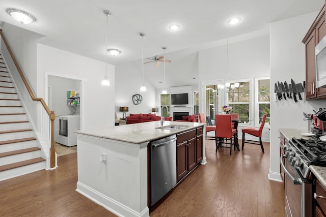 kitchen featuring washer / dryer, light stone countertops, a sink, ceiling fan with notable chandelier, and stainless steel appliances
